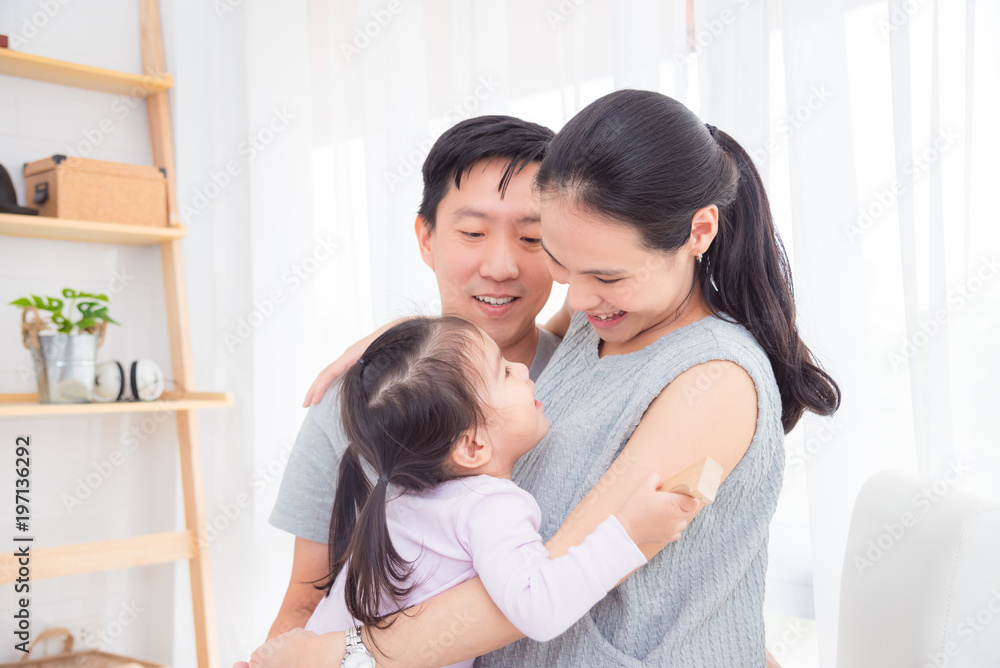 Pregnant mother woman hugging her daughter and her husband at home Pregnant mother woman hugging her daughter and her husband at home
