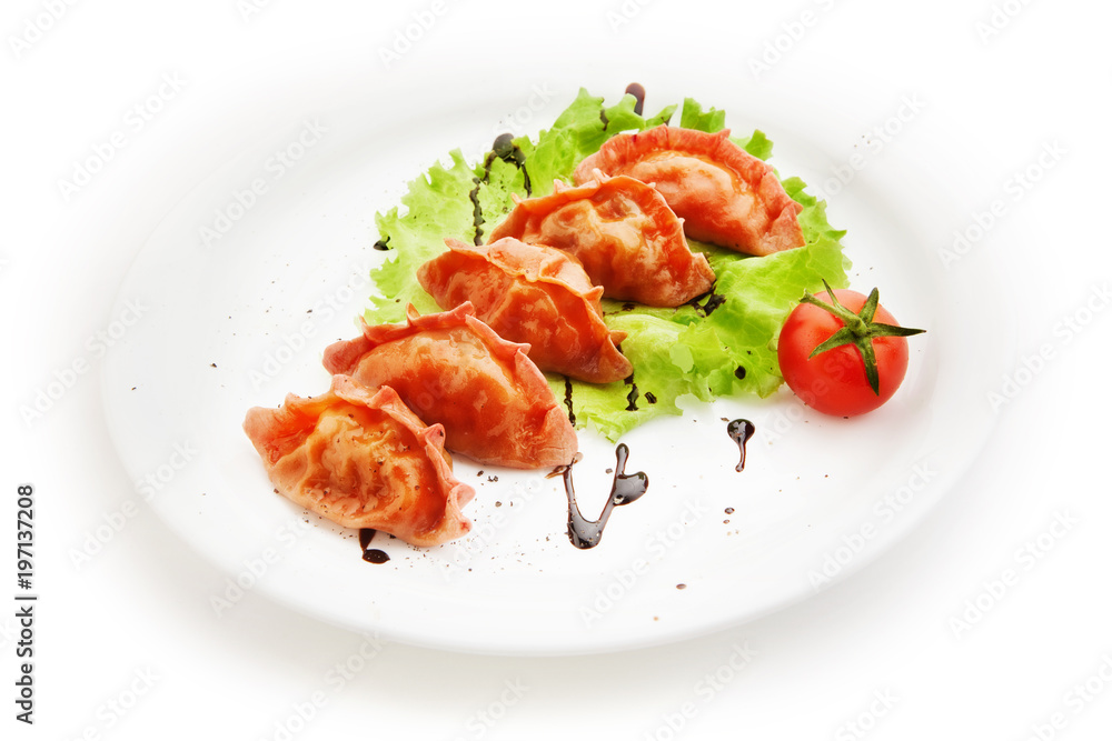 Ravioli with salad and tomato on white background Ravioli with salad and tomato on white background