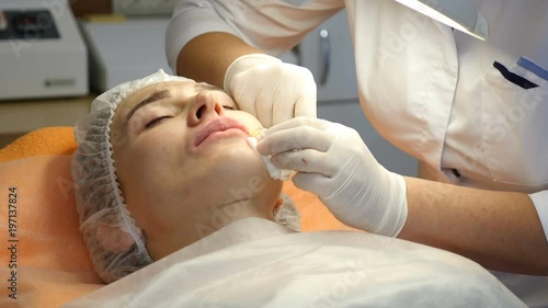 Beauty clinic. Beautician hands in gloves making face aging injection in a female skin. A woman gets beauty facial cosmetology procedure. Botox. collagen injections. Shot in 4k photo