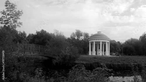 rotunda and bridge in the city park black and white timelapse