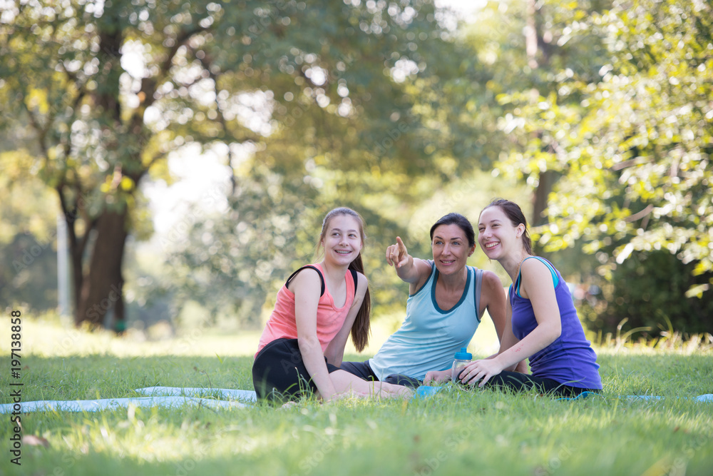 Families with young Russian mother and daughter are talk about exercise. After practice yoga at the park finished. Health and Fitness concept Families with young Russian mother and daughter are talk about exercise. After practice yoga at the park finished. Health and Fitness concept