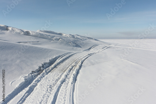 Traces from a snowmobile on a snow surface of the river, Ob Reservoir, Russia