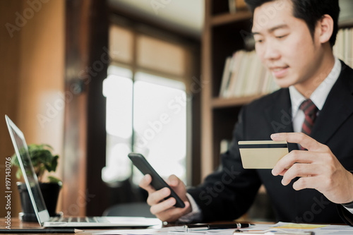 man holding credit card and using laptop and smartphone shopping website online, shopping concept