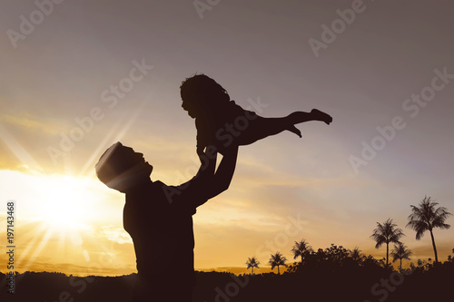 Silhouette of happy father and little girl playing together