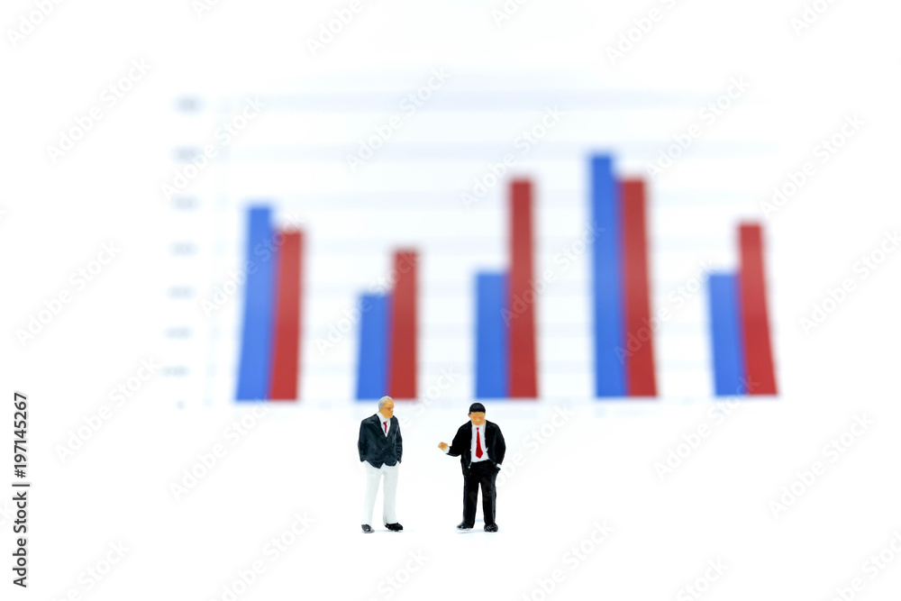 Miniature people : Businessman stand with Financial graphs analysis. Miniature people : Businessman stand with Financial graphs analysis.