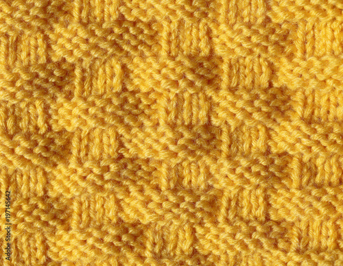 Knitting from woolen threads of a beautiful pattern with a braid pattern. The texture of acrylic is orange  the sample is made by handwork.