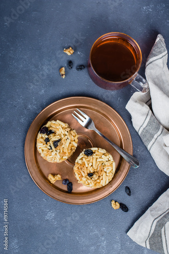 Eastern or Asian sweets (chak-chak) with honey, raisins and walnut on stone concrete table background. Copy space, top view