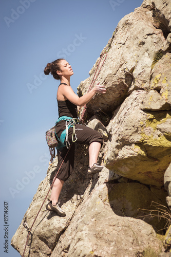 women climbing a rock wall