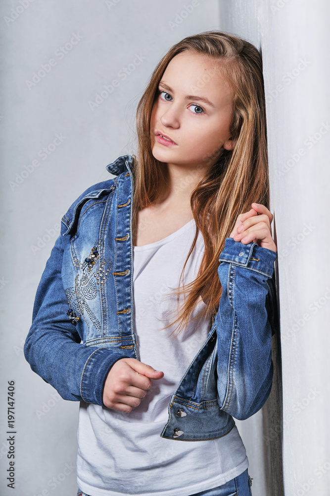 Fashion portrait girl near white wall.Stylish beautiful teenager