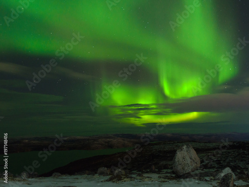 Northern Lights, polar lights above the hills and tundra bay in winter. © Moroshka