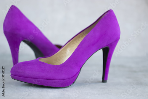 Violet velvet shoes heels on gray background.