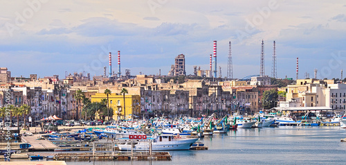 Taranto old town on the sea, fishing boats, docks, industrial plant on background photo