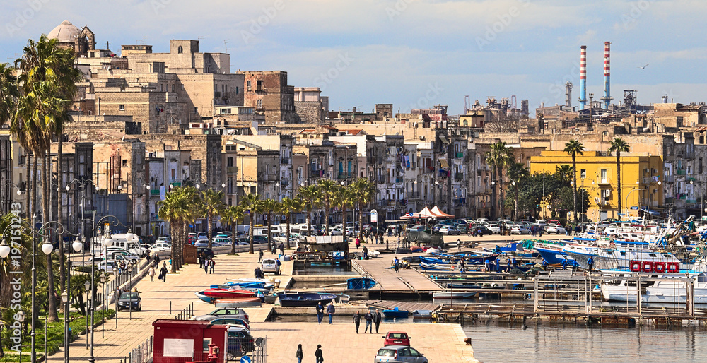 Taranto old town on the sea, fishing boats, docks, industrial plant on background