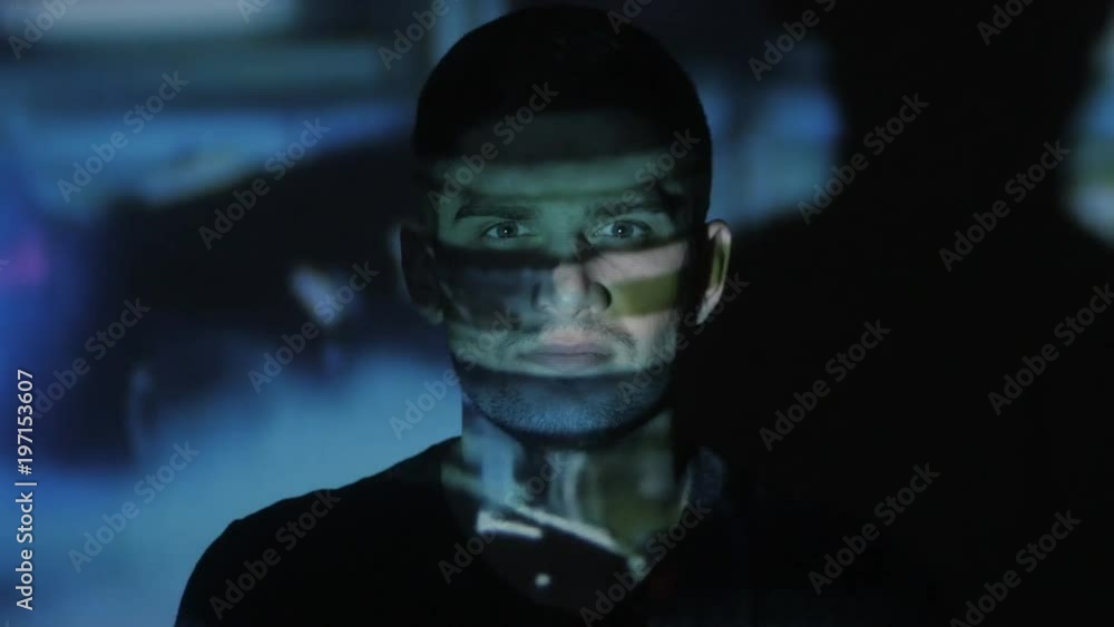 Close up of a young man watching a video or film on TV or a computer monitor. Reflection on his face. Timelapce Close up of a young man watching a video or film on TV or a computer monitor. Reflection on his face. Timelapce