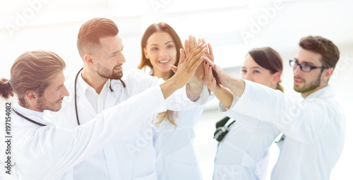 group of doctors giving each other a high five.