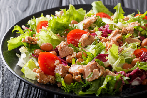 Foto Healthy and delicious food: salad of tuna fish, borlotti beans, tomatoes, mix of lettuce close-up