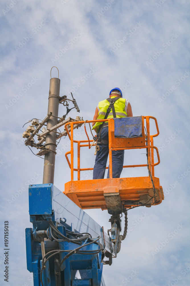 Power line worker fixing from the truck basket. Power line worker fixing from the truck basket.