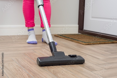 House cleaning. Woman is cleaning using vacuum cleaner