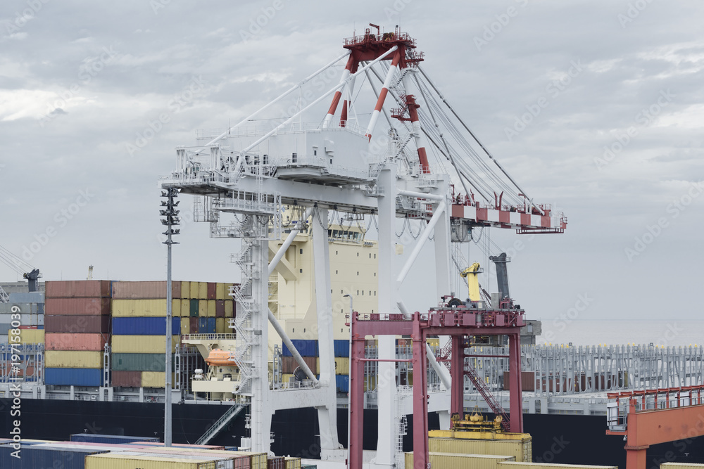 Large harbour crane loading containers on a large cargo vessel