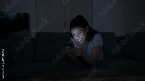 pan shot woman with mobile phone smiling happy and cheerful using dating app sitting at apartment couch internet social media addiction
