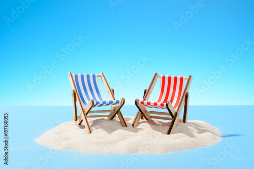 Two sun loungers on a sandy island, copy space © Ramil Gibadullin