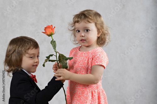 Boy presents a flower to the girl photo