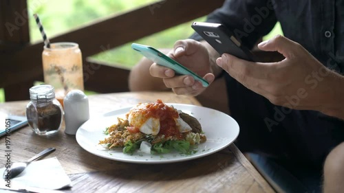 Wallpaper Mural Young man using smartphones during meal in cafe
 Torontodigital.ca