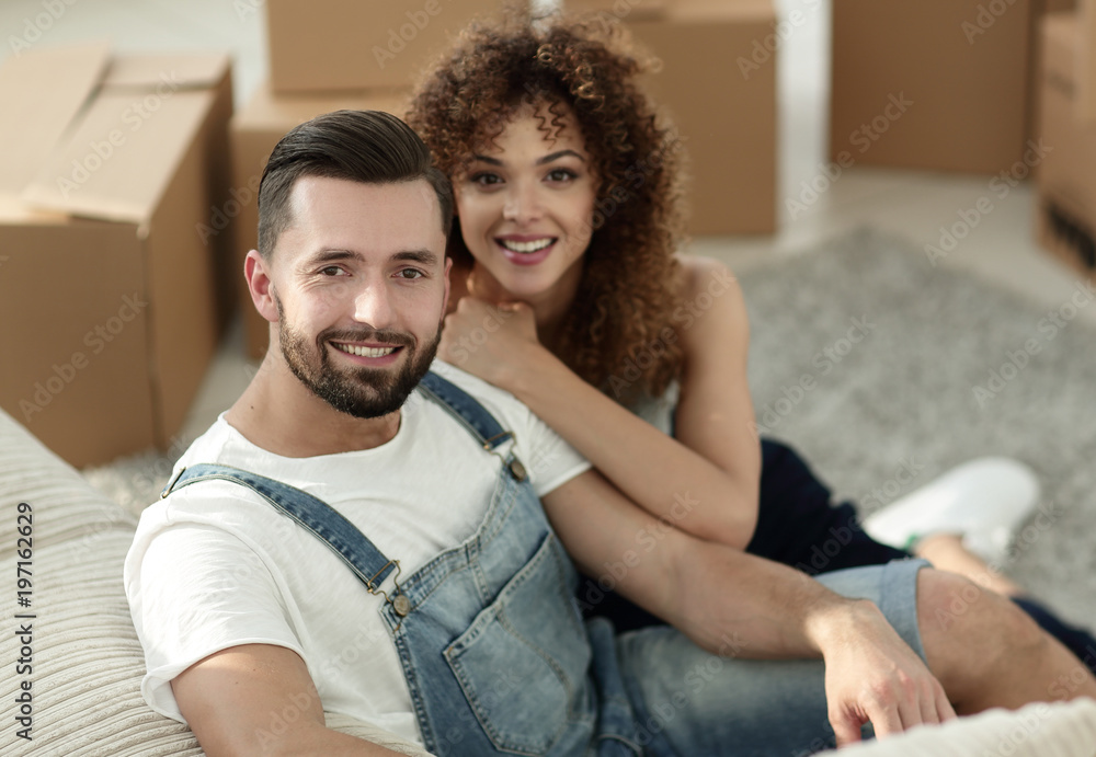 Young couple sitting on the floor in a new apartment Young couple sitting on the floor in a new apartment
