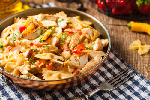 Pasta farfalle with chicken and paprika, in carbonara sauce.