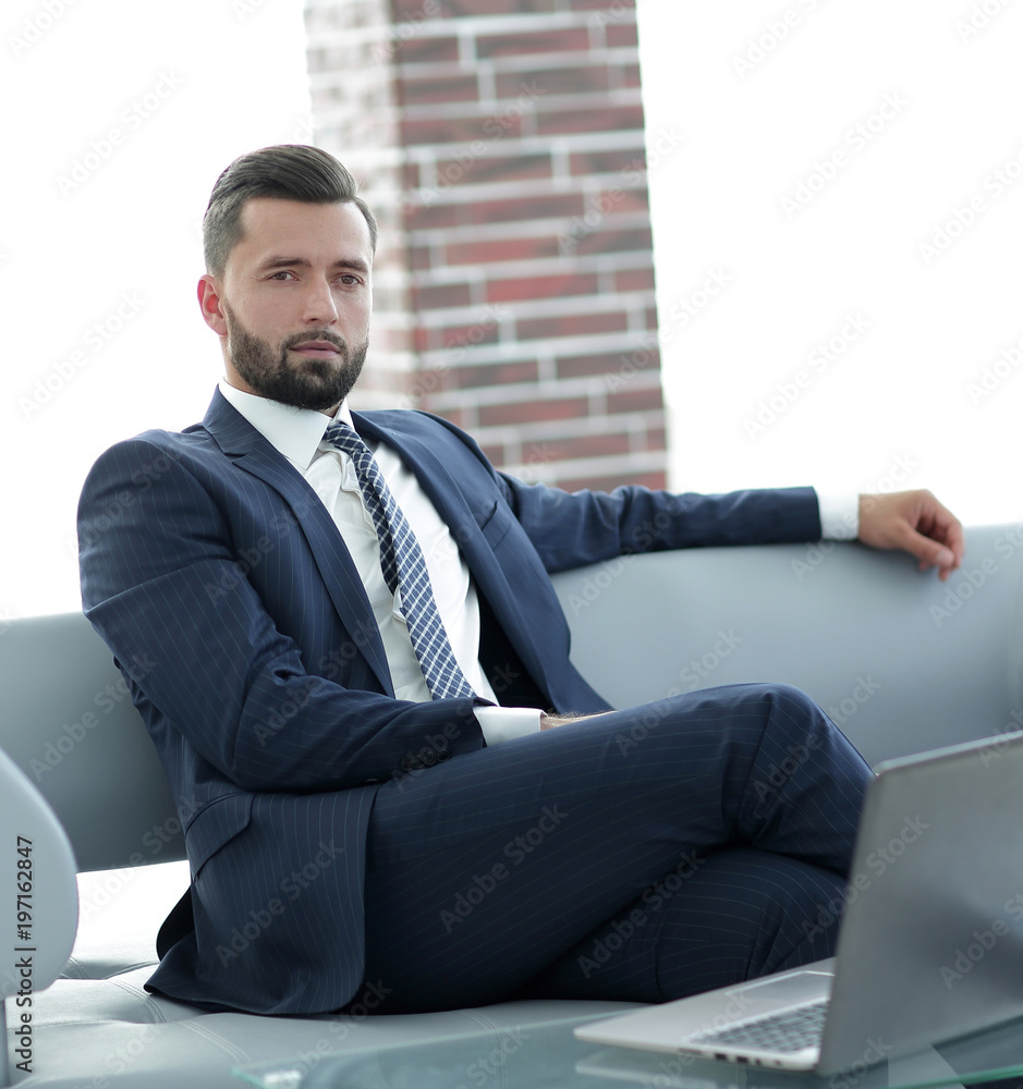 Portrait of a successful businessman sitting in the office lobby. Portrait of a successful businessman sitting in the office lobby.