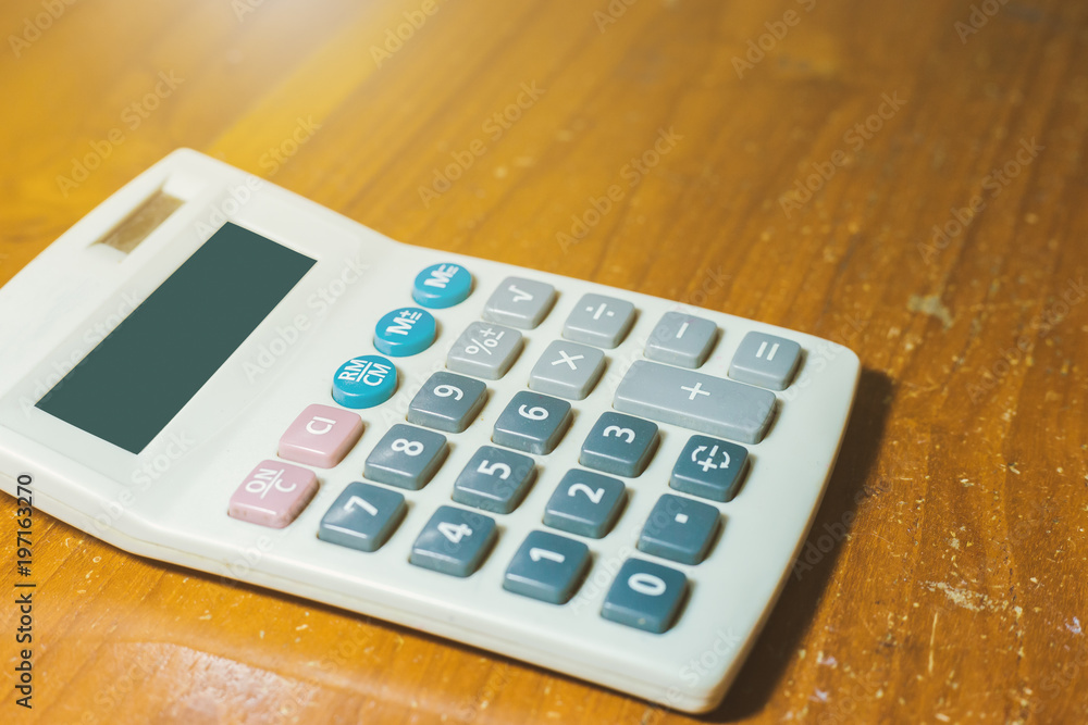 Close-up of old calculator isolated on a wooden background with copy space. Close-up of old calculator isolated on a wooden background with copy space.