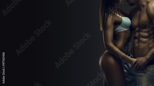 Fitness couple. Artistic portrait of young athletic  shirtless man and woman in underwear in studio