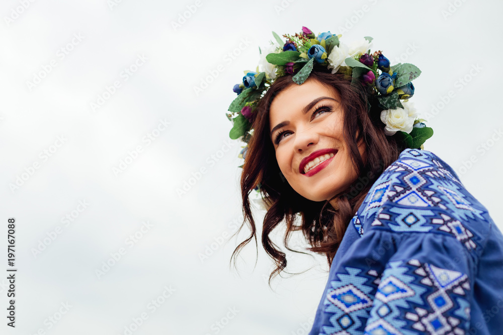 close-up of a beautiful girl with a wreath of flowers on the head who smiles sincerely close-up of a beautiful girl with a wreath of flowers on the head who smiles sincerely