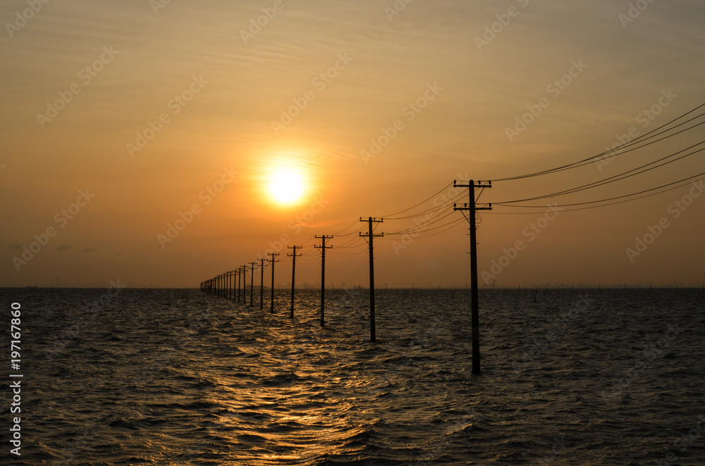 Sunset Over Utility Poles in a Sea