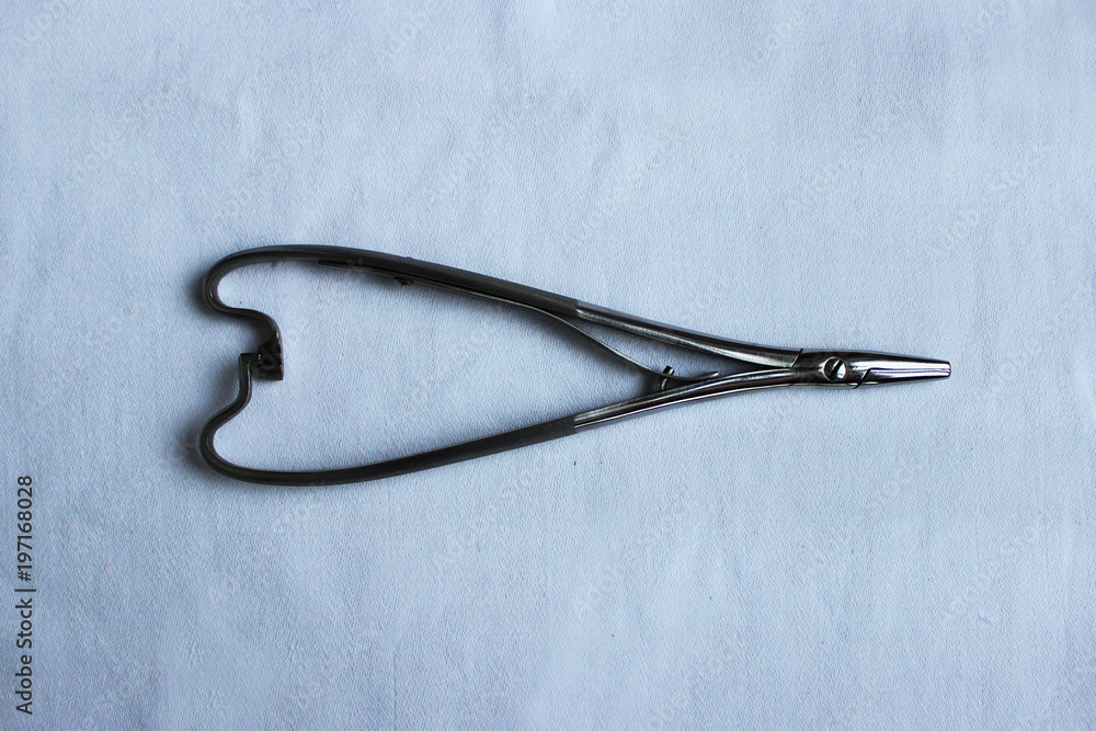 Medical instrument one needle holder lies on a blue cloth. Medical instrument one needle holder lies on a blue cloth.