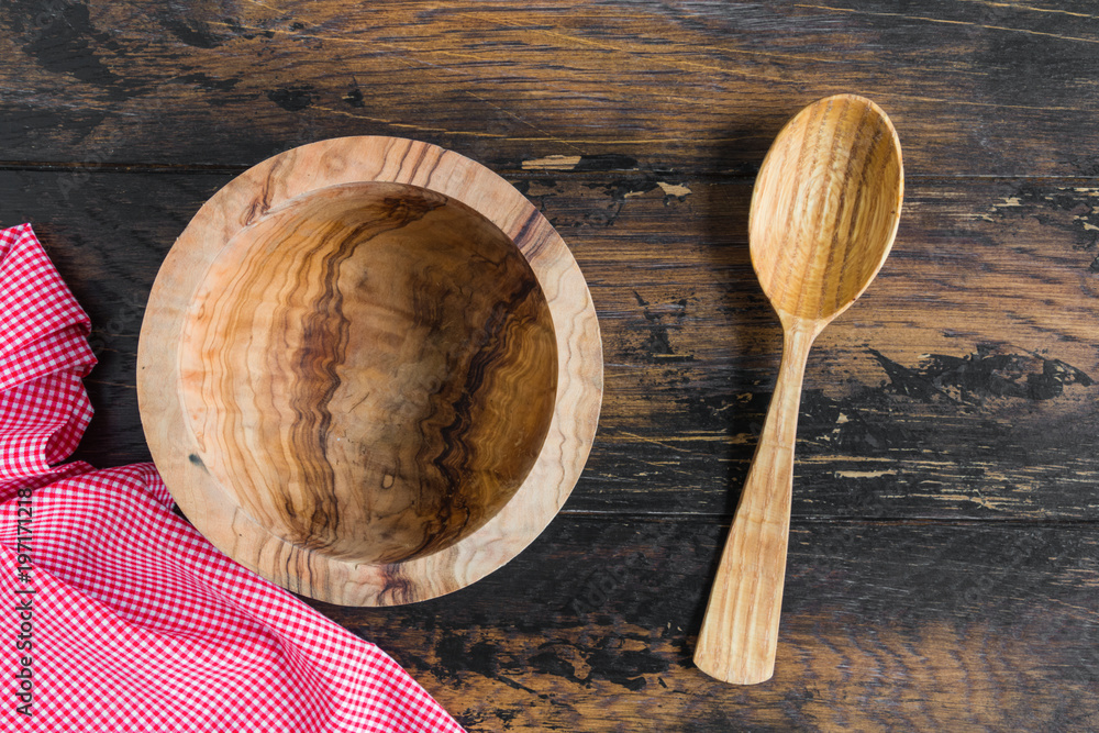 Brown empty wooden bowl and spoon on table, top view. Brown empty wooden bowl and spoon on table, top view.