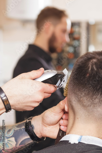 Man getting a haircut by a hairdresser in barber shop