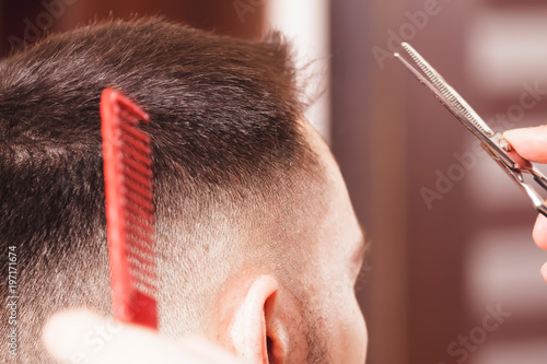 Close up haircut at barber shop with scissors