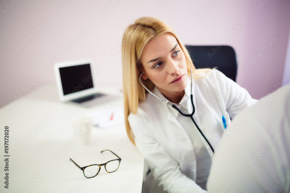 Doctor examining patient with stethoscope in medical office. Doctor using  stethoscope to exam man patient heart. Portrait of female doctor examines a  patient with stethoscope. Stock Photo | Adobe Stock