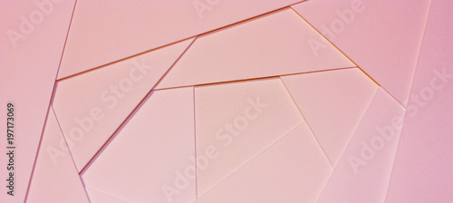 Abstract geometric background in light pastel tones from sheets of thick pale pink paper, cardboard.