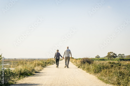 Obraz na płótnie Elderly couple in love walking on a dust road, Portugal w salonie