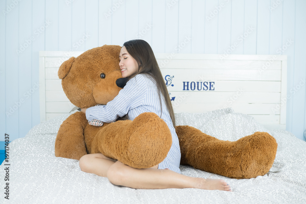 Sweet Asian girl sleeping on the bed with a big brown teddy bear. Stock  Photo | Adobe Stock