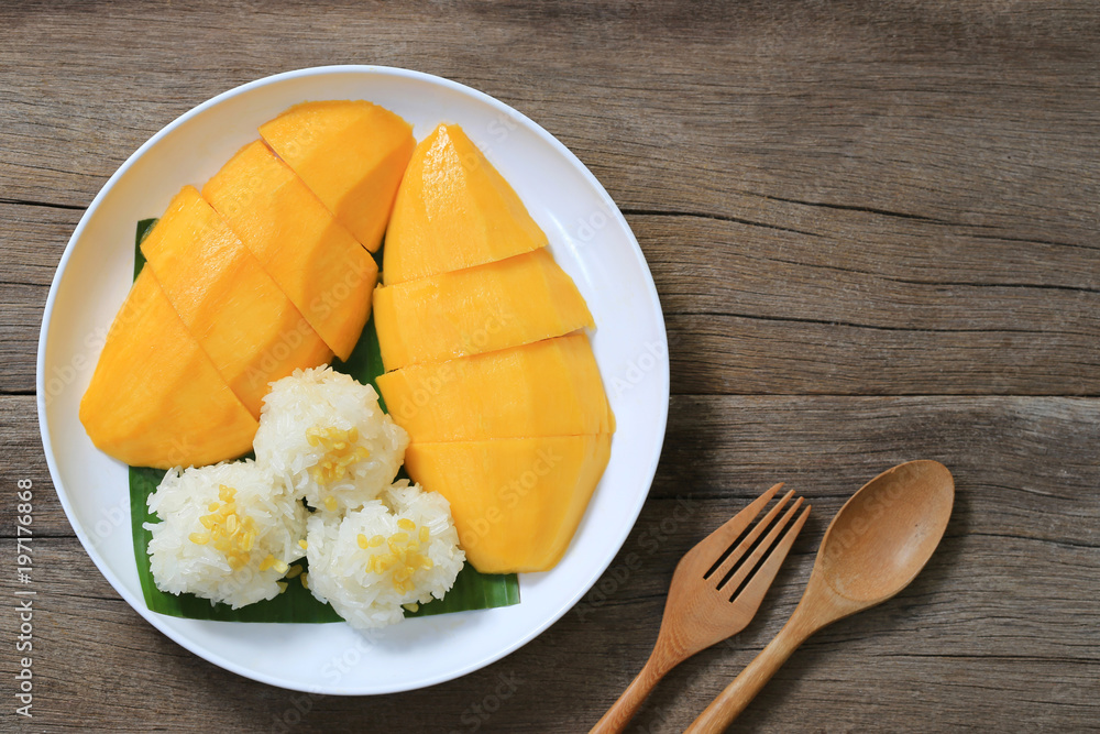 Mango and sticky rice in the white dish on wooden floor,Thai dessert popular in the summer of Thailand.