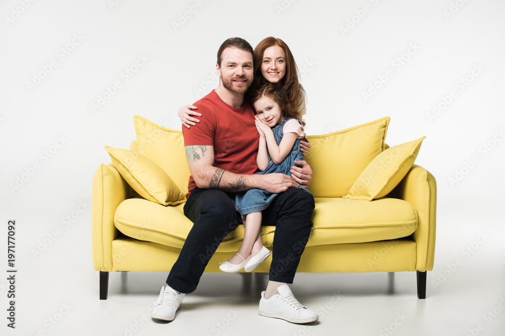 Little kid sitting on father knees with mother behind isolated on white Little kid sitting on father knees with mother behind isolated on white