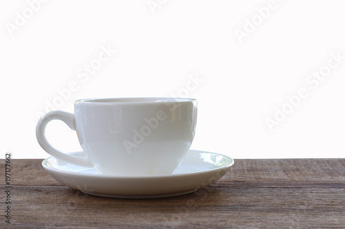 White coffee mug placed on a brown wood floor isolated on white background.