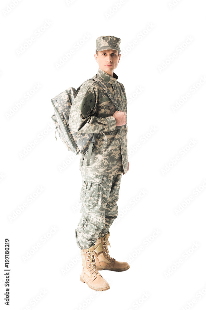 Handsome army soldier in uniform holding backpack isolated on white Handsome army soldier in uniform holding backpack isolated on white