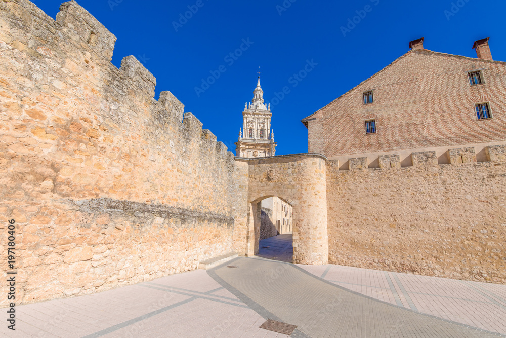 main public access to Burgo de Osma medieval town, with public street and tower of cathedral, landmark and monument from thirteenth century, in Soria, Spain, Europe
