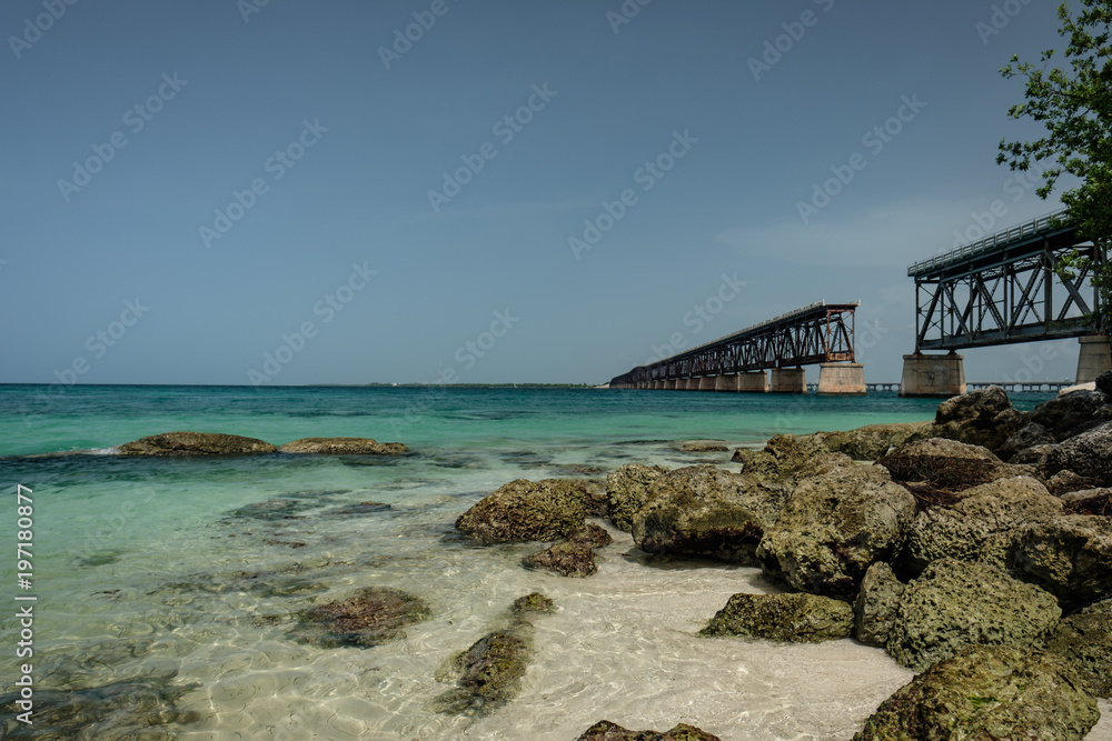 Clear and warm beaches of the Florida Keys with the historic Flagler built railroad bridge in the background