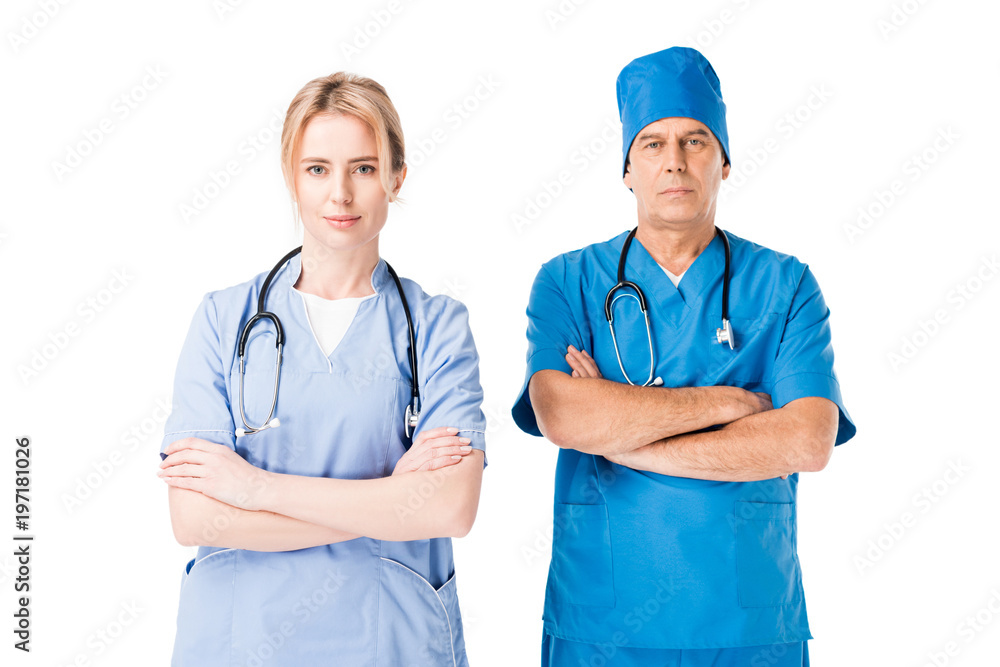 Medical crew nurse and doctor in uniform with stethoscopes standing with arms folded isolated on white Medical crew nurse and doctor in uniform with stethoscopes standing with arms folded isolated on white