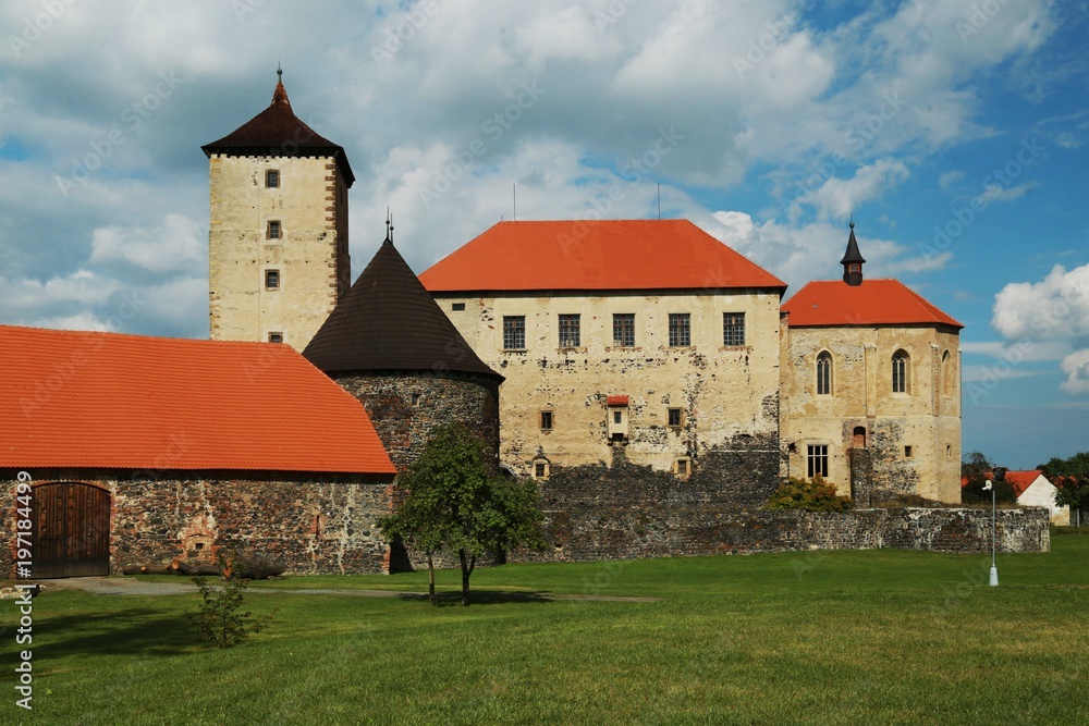 Famous water castle Svihov in the Czech Republic, Europe, tower, palace, church, red roofs, beautiful scenery with blue sky, white clouds, green grass, tree